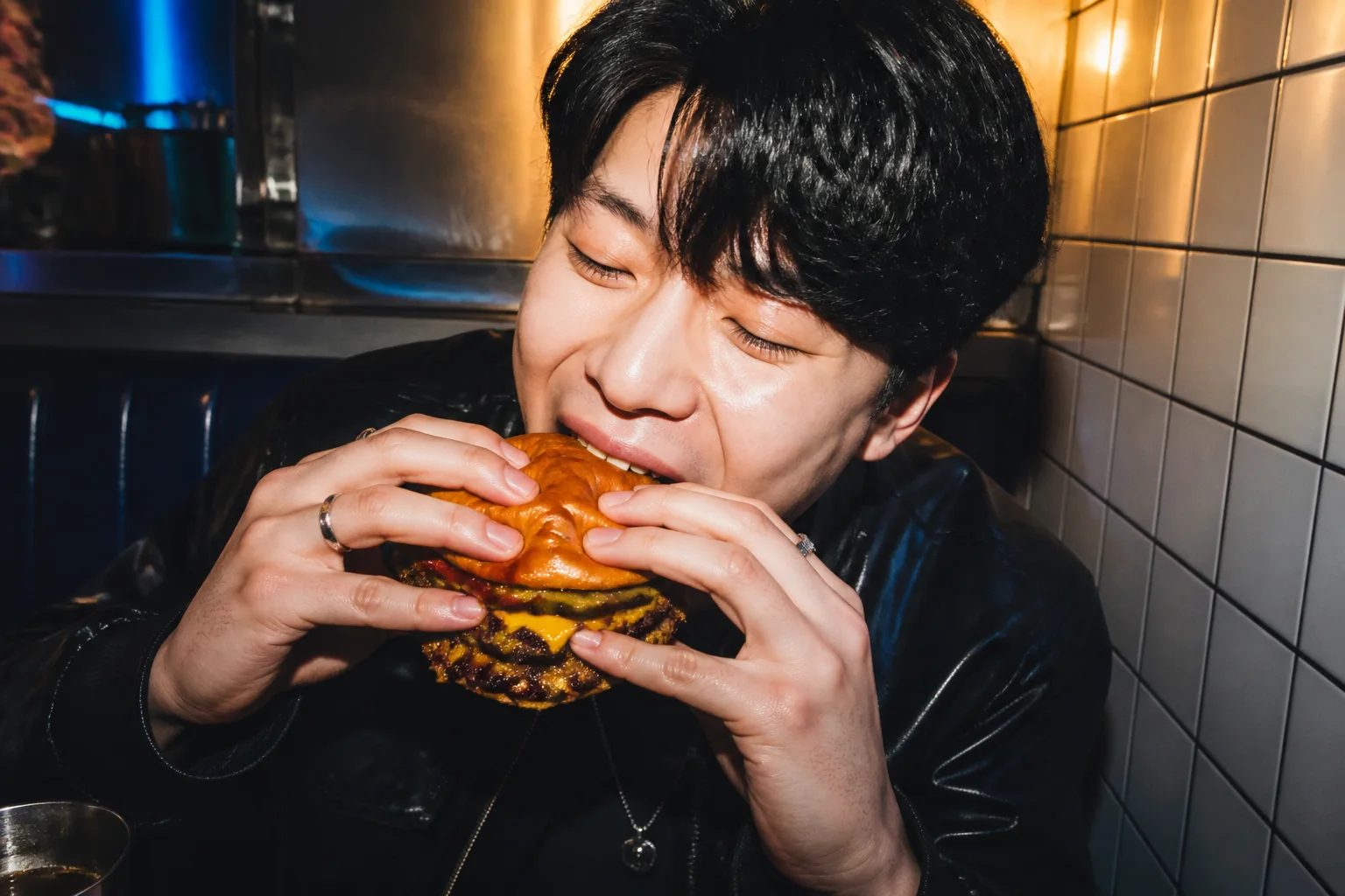 서울 번 더블 버거를 한입 베어 무는 손님